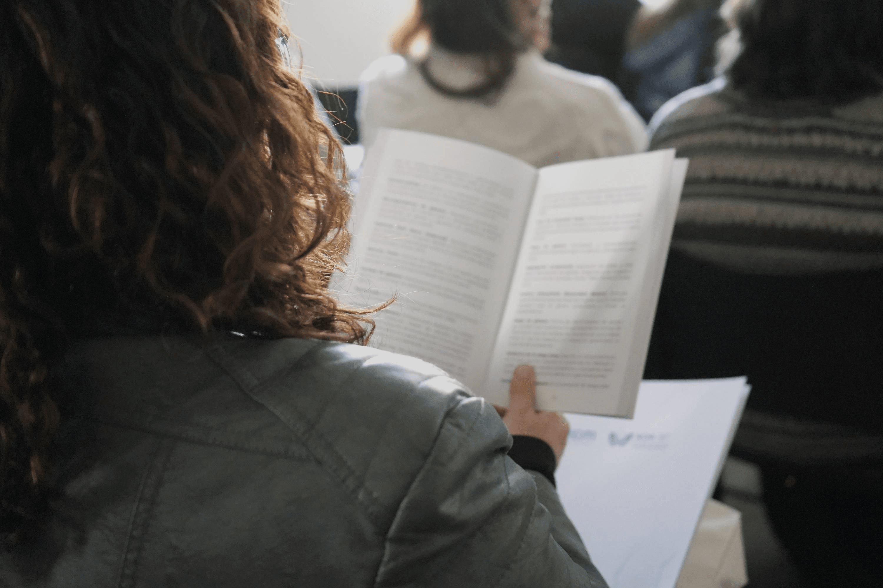 Una persona está leyendo un documento en un ambiente de reunión.