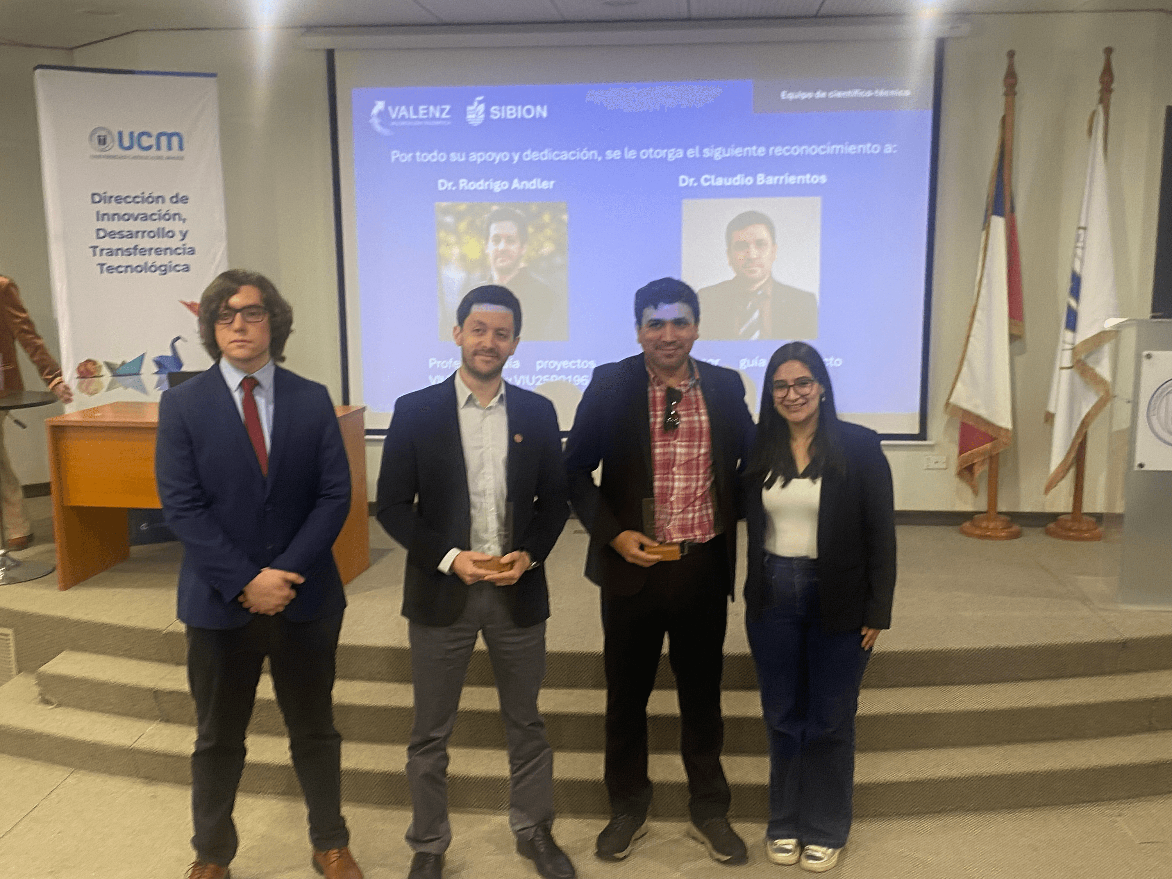 Cuatro profesionales se presentan en un evento de reconocimiento en una institución educativa.