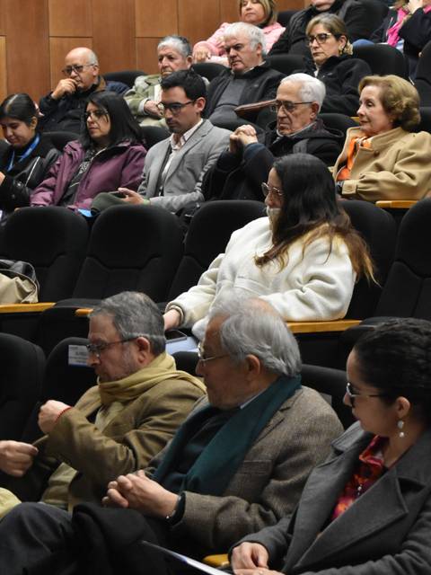 Un grupo de personas sentadas en un auditorio durante un evento.