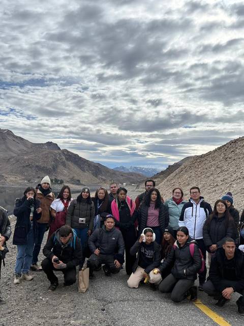 Grupo de amigos disfrutando de una excursión en la montaña junto a un lago.