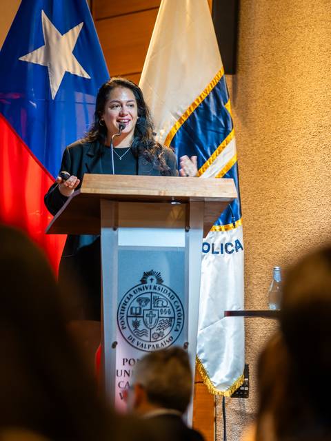 Una mujer se encuentra dando una charla en una conferencia en la Universidad Católica de Valparaíso.