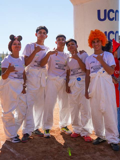 Un grupo de estudiantes disfrazados con trajes divertidos en un evento escolar.