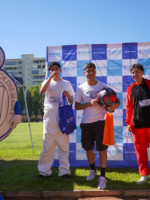 Un grupo de jóvenes sonrientes posando en un evento deportivo en la Universidad Católica del Maule.