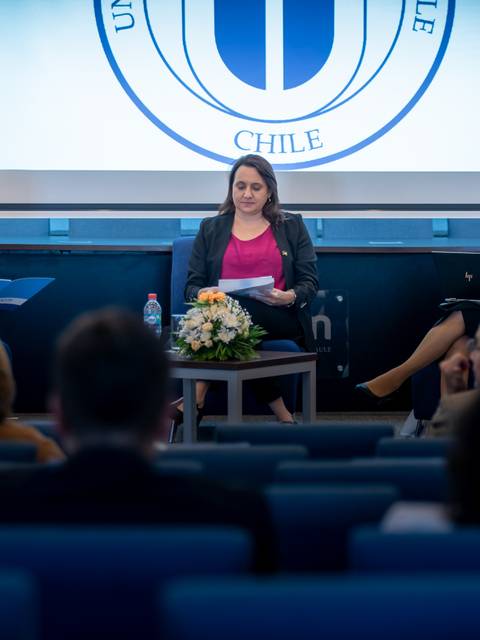 Una mesa de discusión en la Universidad de Chile con tres panelistas.