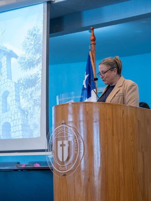 Una mujer presentando en un evento de certificación en una institución educacional.