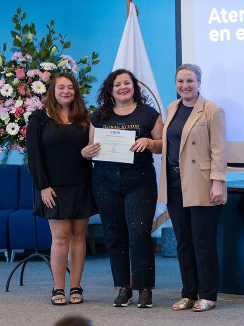 Tres mujeres posando en un evento de reconocimiento académico en Chile.