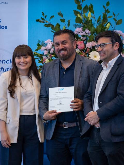 Un grupo de tres personas celebra la entrega de un certificado en un evento académico en Chile.