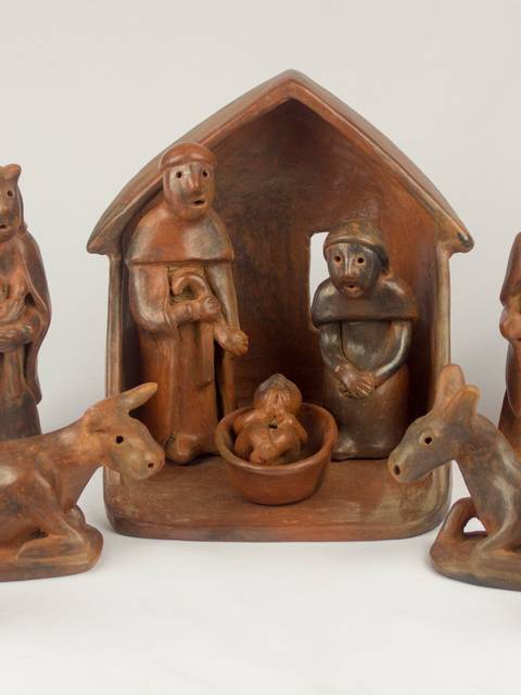 La imagen muestra un conjunto de figuras de cerámica que representan un nacimiento, con pastores y animales alrededor.