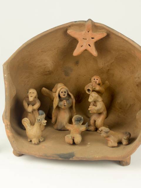 Un nacimiento de cerámica con figuras de la Sagrada Familia y animales en su interior.