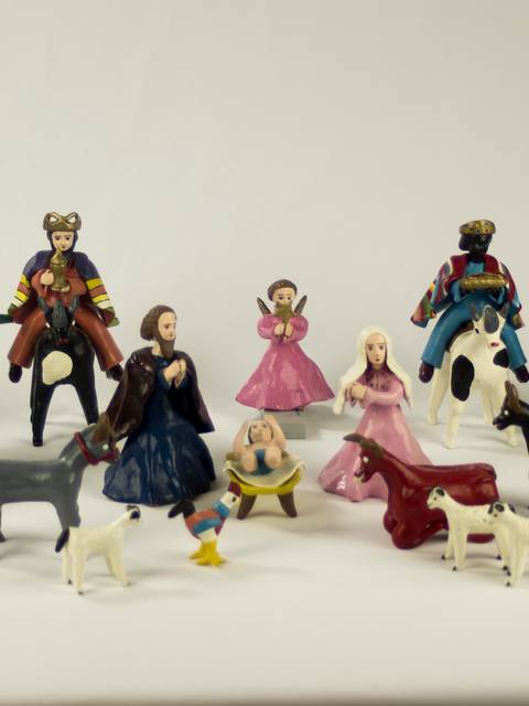 La imagen muestra una colección de figuras de cerámica que representan personas y animales en un entorno rural.