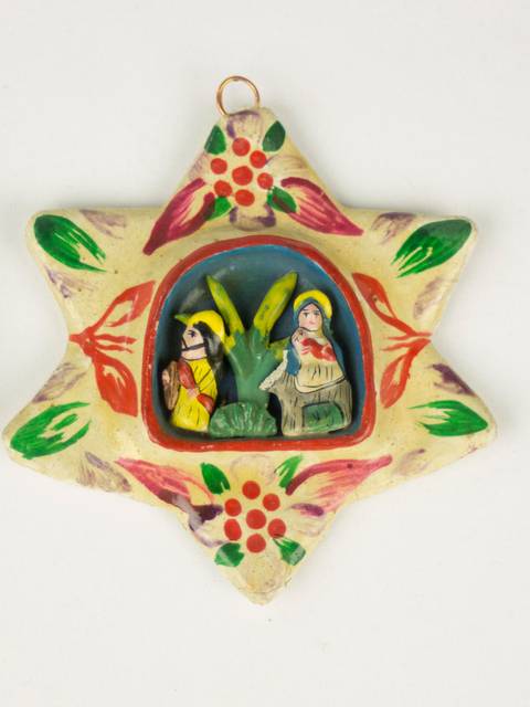 Un objeto decorativo en forma de estrella con figuras talladas en su interior.