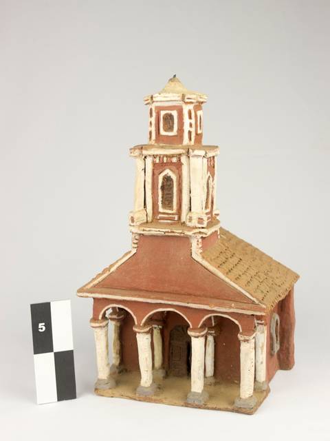 La imagen muestra una maqueta de una iglesia con columnas y un campanario.