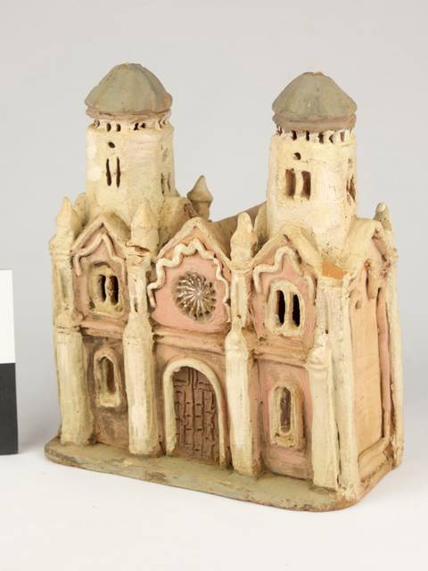 Una maqueta de una iglesia con dos torres y detalles arquitectónicos en tonos tierra.