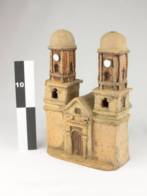 La imagen muestra una estructura arquitectónica de cerámica con dos torres y una puerta central.