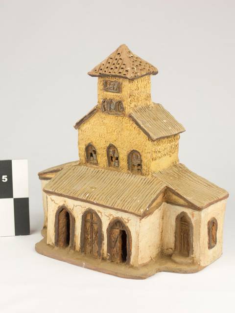 Una maqueta de una edificación con detalles arquitectónicos en tonos amarillos y marrones.