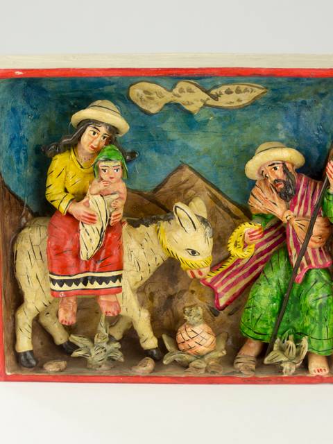 Una escena escultórica que muestra a tres personas y un animal en un paisaje montañoso.