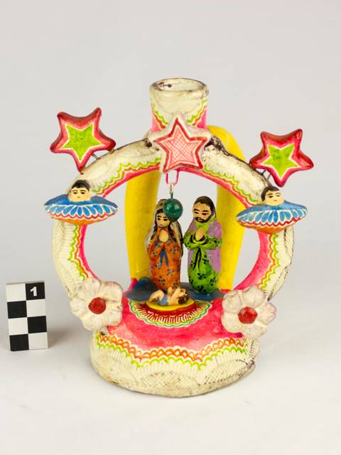 Una figura decorativa con personajes y estrellas de colores, sobre un fondo blanco.