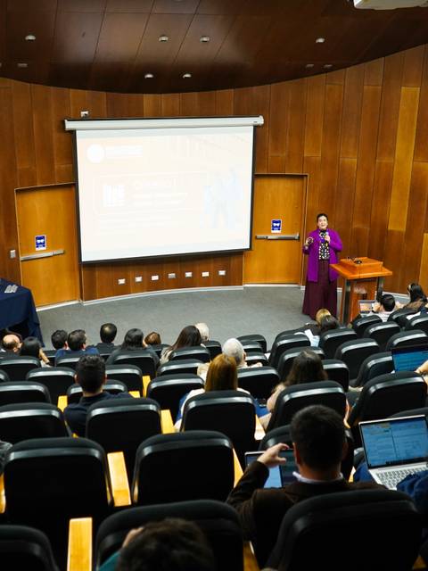 Una charla en una sala de conferencias con un público atento.