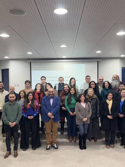 Un grupo grande de personas posando en una sala de clases.