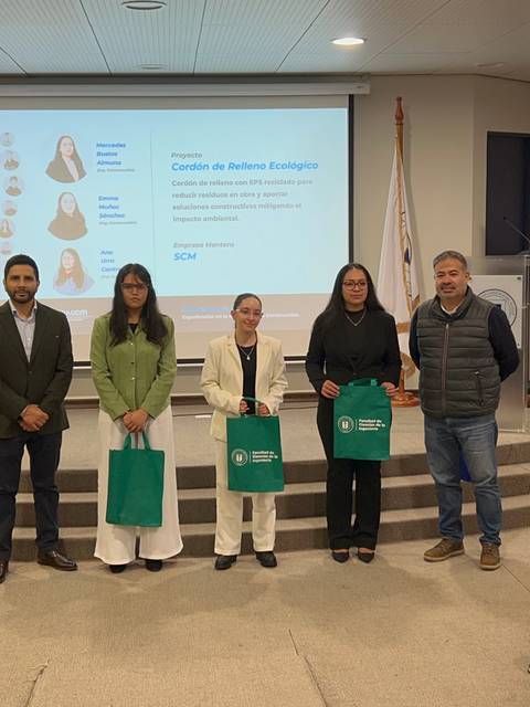 Un grupo de personas posando con bolsas en un evento de entrega de reconocimientos.