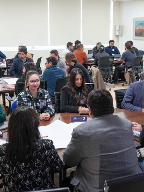 Un grupo de personas en una reunión colaborativa en un salón de clase.