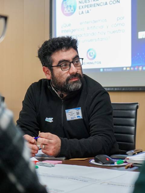 Un hombre con barba y gafas participa en una reunión sobre inteligencia artificial.