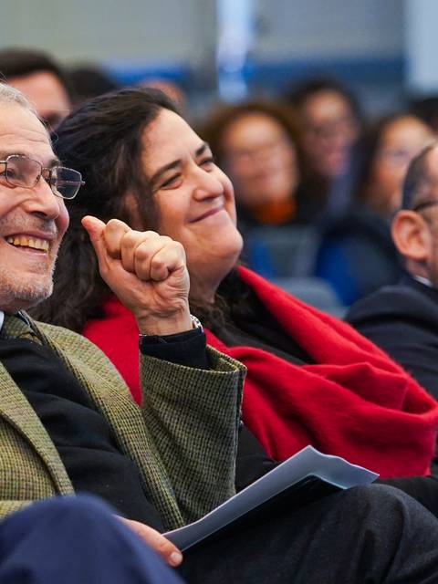 Un grupo de personas sonrientes disfrutando de un momento en una charla o evento.