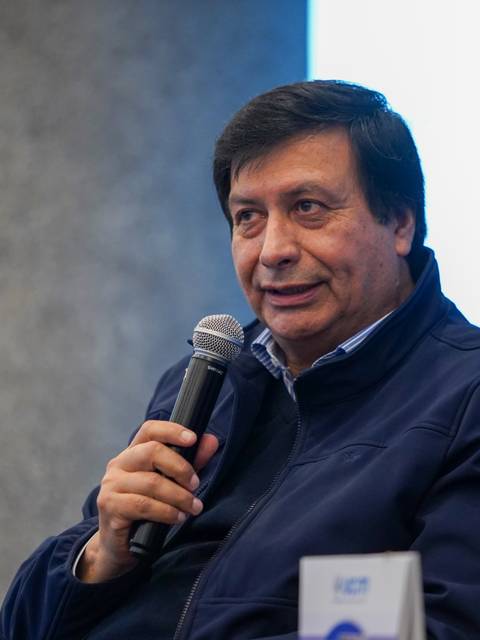 Un hombre con micrófono, compartiendo en un evento de conversación.