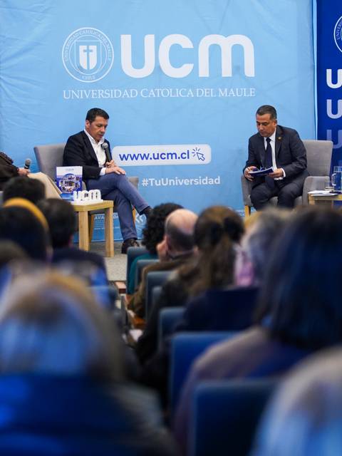Un panel de discusión en la Universidad Católica del Maule con varios exponentes y un público atento.