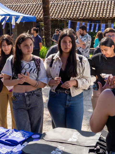 Un grupo de jóvenes se reúne en un evento, escuchando atentamente a una expositora.