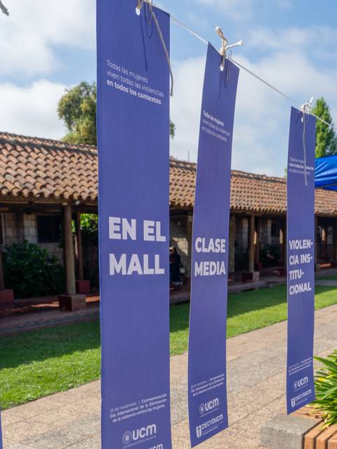 Una exposición al aire libre con carteles que abordan temas sociales en un entorno escolar.