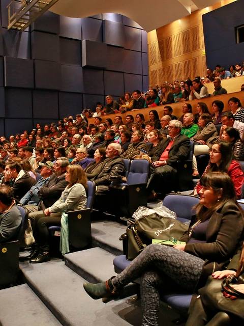 Una multitud de personas sentadas en un auditorio durante un evento.