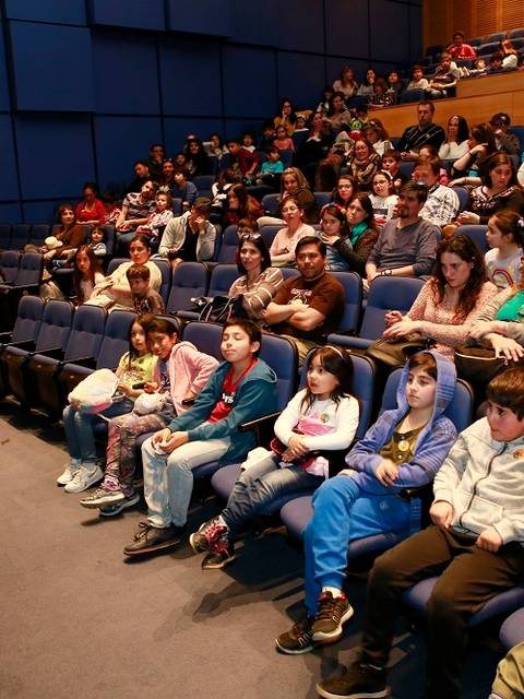 Un grupo de personas observa una presentación en un auditorio.