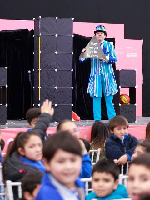 Un mago entretiene a un grupo de niños en un espectáculo infantil.