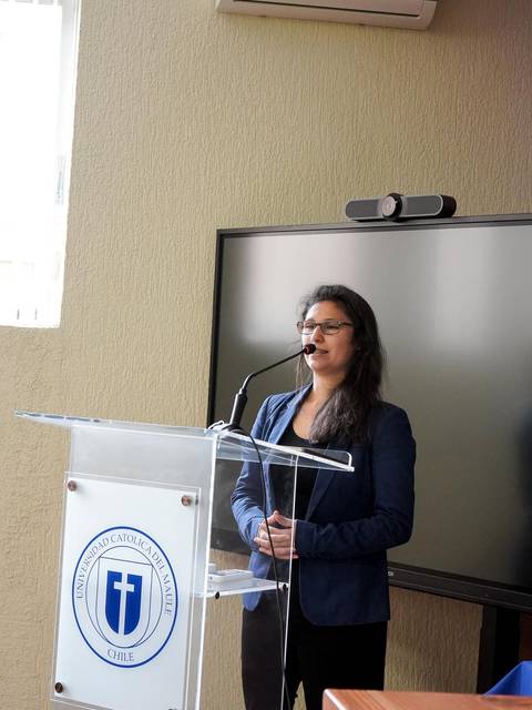 Una mujer está hablando detrás de un atril en una sala de conferencias.