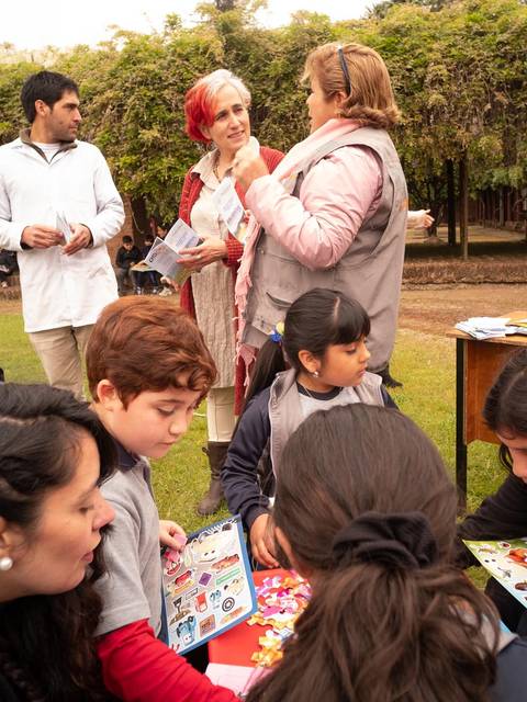 Un grupo de personas participa en actividades al aire libre con niños en un ambiente escolar.