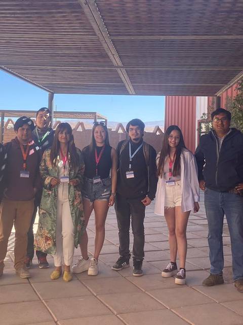 Grupo de personas sonriendo en un espacio al aire libre.