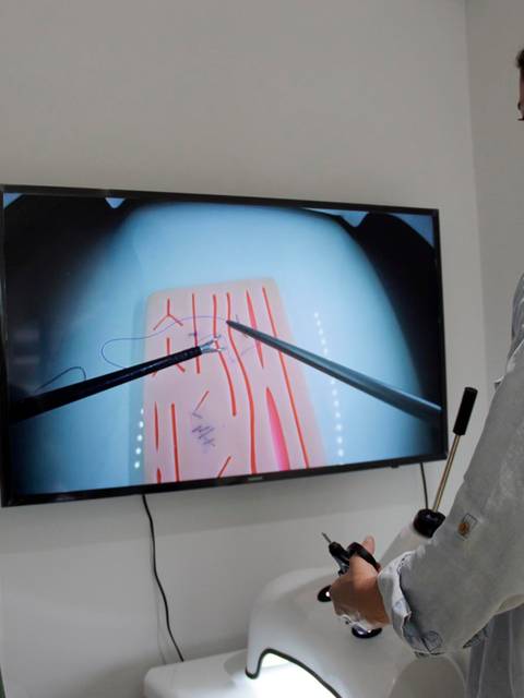 Dos personas interactuando con una pantalla que muestra un diseño rojo sobre un fondo claro.