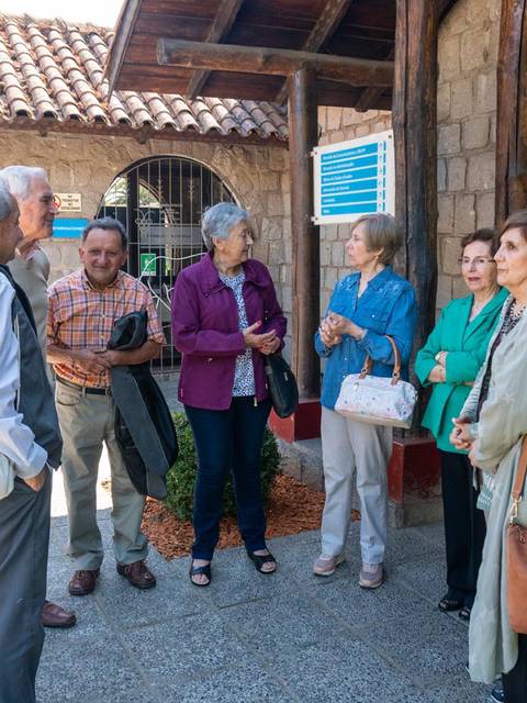 Un grupo de personas conversando en un lugar al aire libre.
