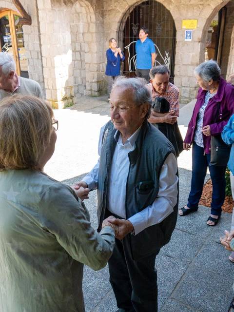 Un grupo de personas mayores socializando en un entorno al aire libre.