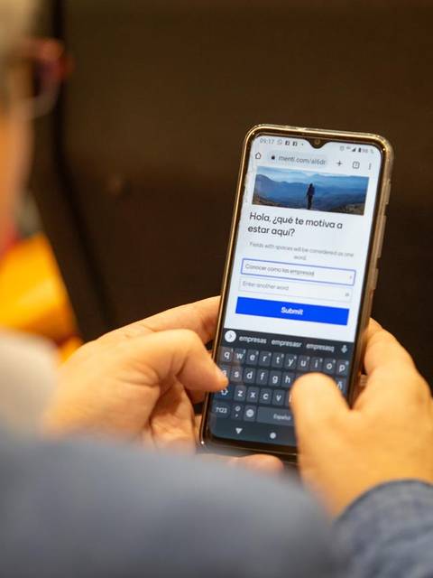 Una persona usando un teléfono móvil en un entorno interior.