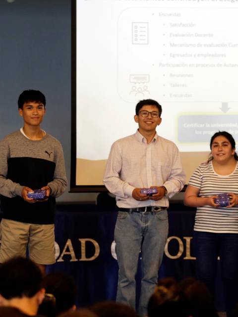 Un grupo de estudiantes recibe reconocimientos en un evento académico.
