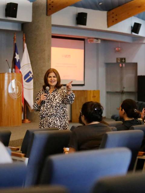 Una mujer está hablando frente a un grupo de personas en una sala de conferencias.