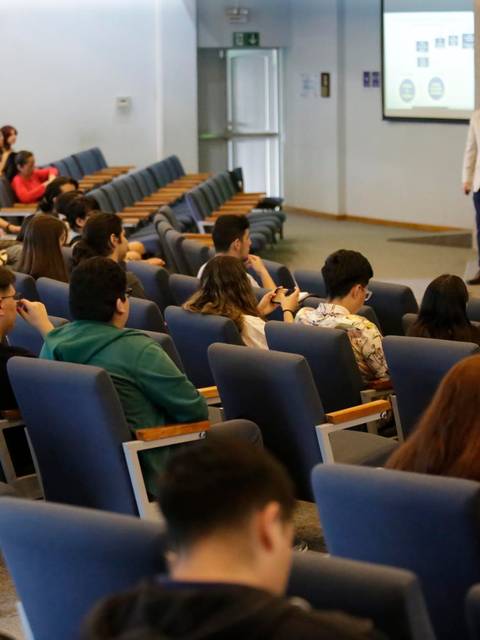 Un grupo de personas asiste a una conferencia en un auditorio.
