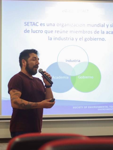 Un hombre presenta información sobre la organización SETAC en una conferencia.
