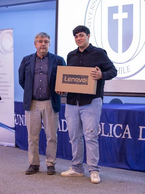 Un joven recibe un premio en un evento académico en la universidad.