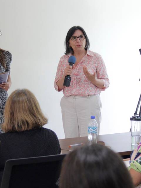 Dos mujeres están dando una presentación frente a un grupo de personas en una sala.