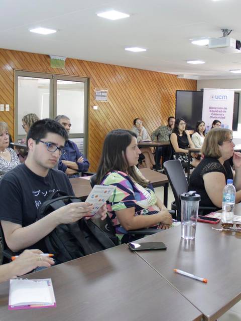 Un grupo de personas asiste a una presentación en un aula.