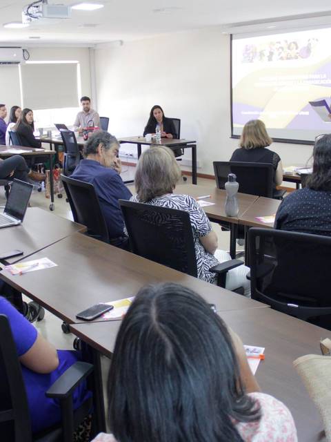 Una presentación en un aula con varias personas escuchando atentamente.