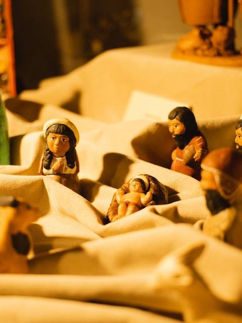 La imagen muestra una representación de figuras artesanales en una escena que parece recrear un momento especial.